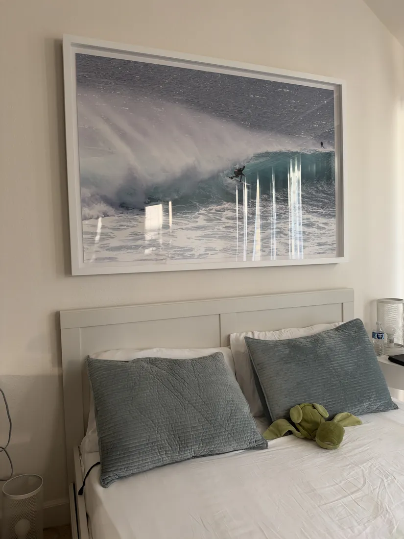 Large framed surf print hung over a bed in Newport Beach, October 2026