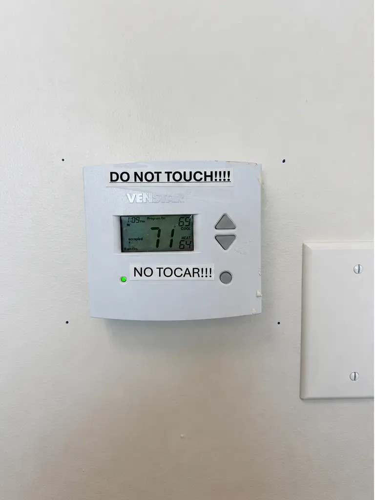 Exposed wall thermostat before protective lock box, Orange County